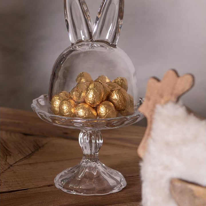 Eine Clayre & Eef - Glasglocke auf Fuß Hase-förmige Schale, gefüllt mit Schokoladeneiern.