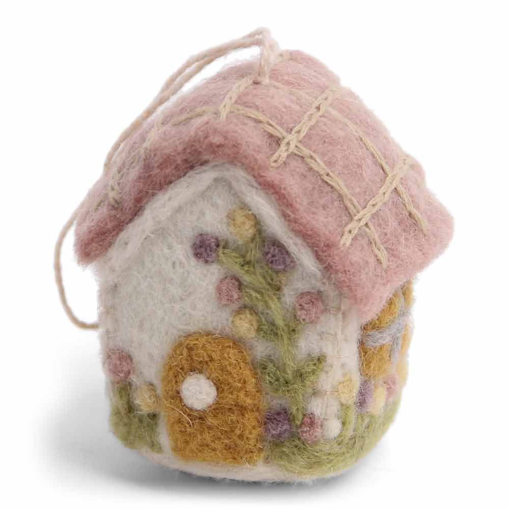 Ein kleines, handgefertigtes Gry & Sif-Anhänger Haus aus Filz-Ornament mit einem rosa Dach und Blumendekorationen, isoliert auf weißem Hintergrund.
