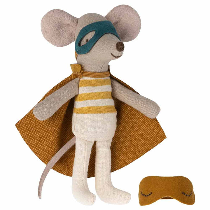 Ein Maileg – Maus Little Brother Super Hero in einer Streichholzschachtel, als Superheld verkleidet mit Umhang und Augenmaske, neben einer kleinen, separaten Schlafmaske stehend.