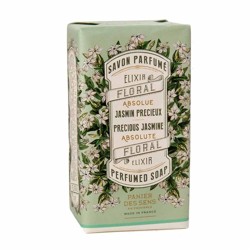 Ein Stück parfümierte Seife von Panier des Sens in einer grünen Schachtel mit Blumenmuster und der Aufschrift „Savon Parfumé, Blumenelixier, Jasmin-Absolue, hergestellt in Frankreich.“