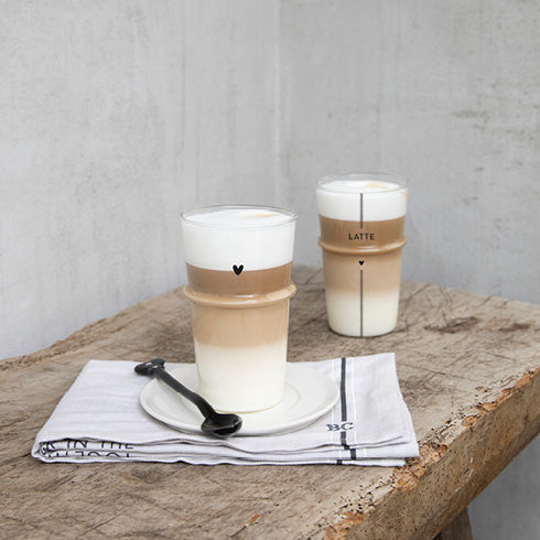 Zwei Tassen Bastion Collections - Löffel für Latte Macchiato Herz schwarz auf einem Holztisch.
