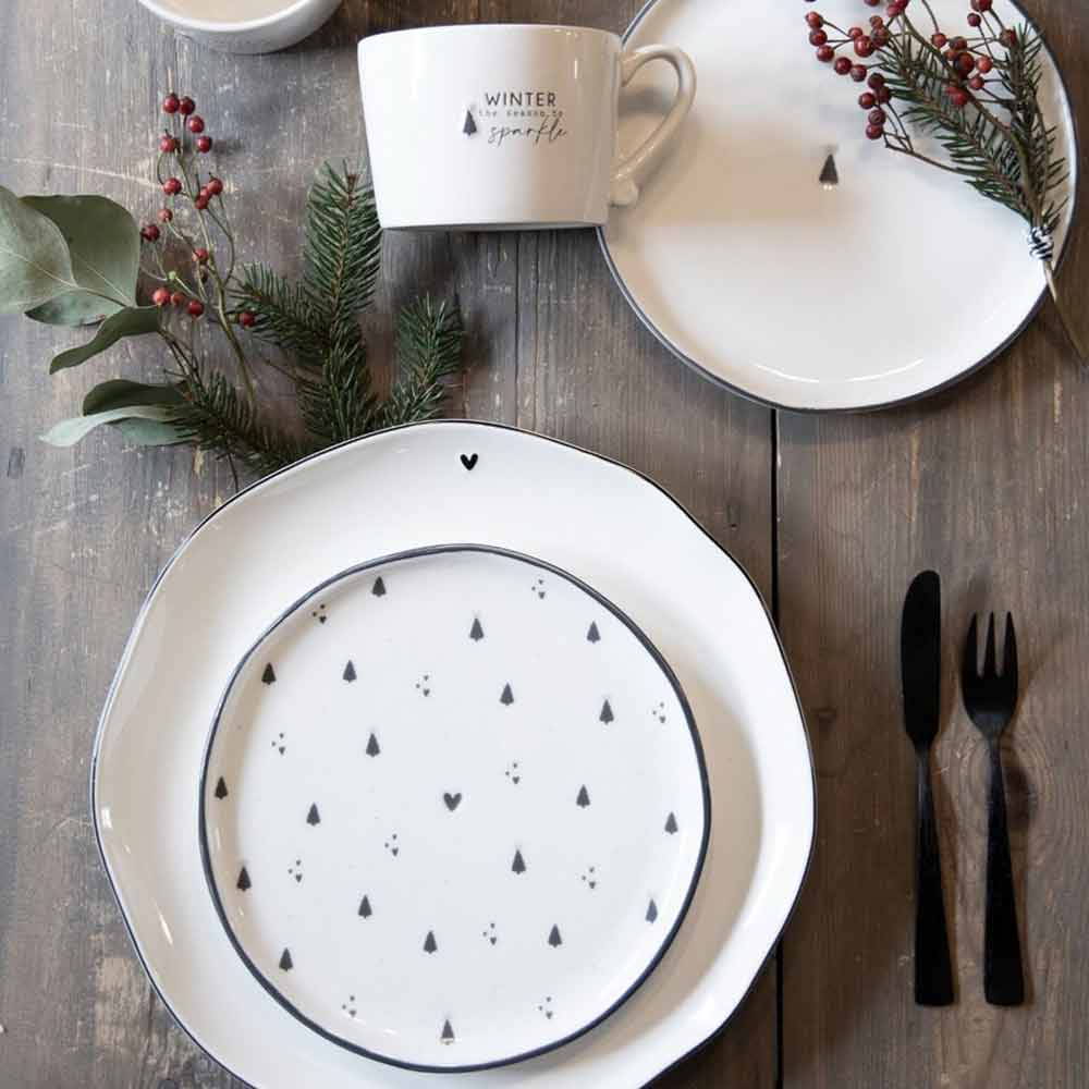 Ein Set aus weißem Geschirr mit dem schwarzen Muster „Bastion Collections – Dessertteller Little Christmas Tree“.
