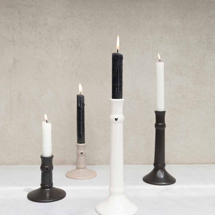 A Bastion Collections - Kerzenständer für Stabkerze Herz schwarz 20 cm auf einem Tisch.
