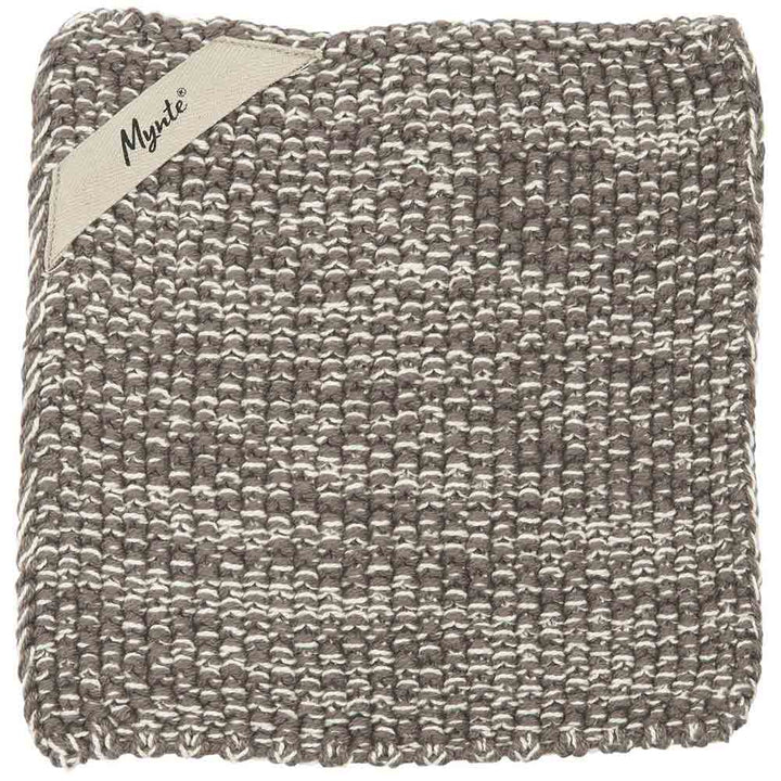 Eine strukturierte graue gefaltete Decke mit einem sichtbaren Etikett mit der Aufschrift „Ib Laursen – Topflappen Mynte“.