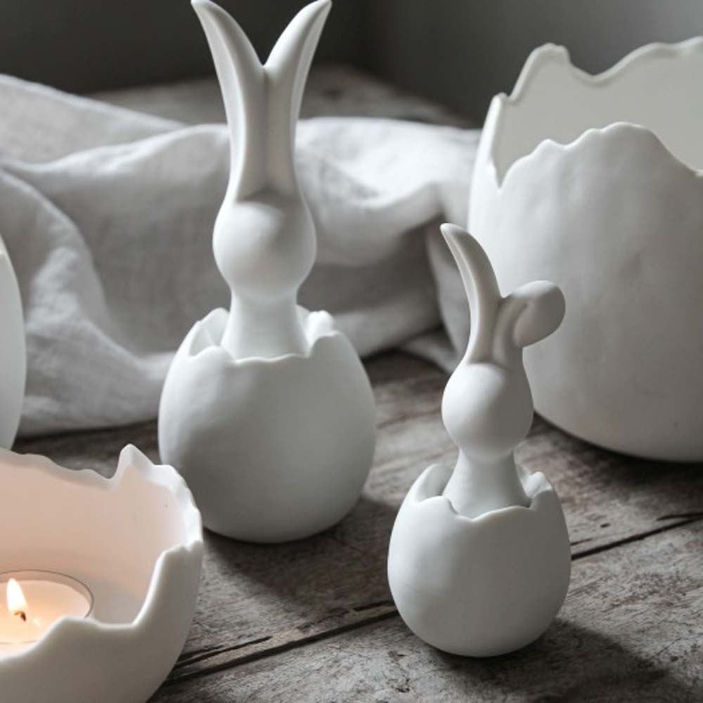 Drei weiße Keramikvasen Majas Cottage - Hase in Eierschale 16 cm auf einem Tisch.