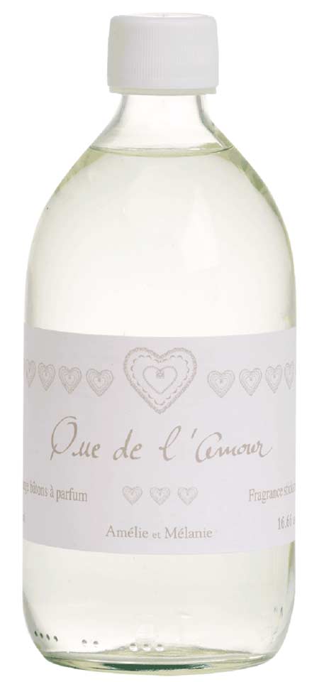 Durchsichtige Flasche der Duftstäbchenlösung „Amélie et Mélanie – Que de l'amour“ mit weißem Etikett und Herzdesign.