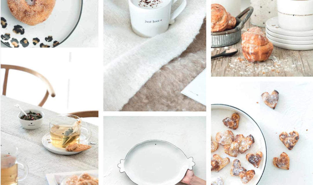 Eine Collage aus Frühstücksartikeln wie Bagels, Gebäck, herzförmigen Keksen, Tee und einer Tasse auf einem hellen Tisch mit neutralen Farbtönen.