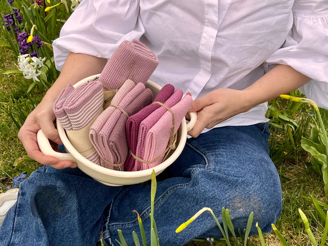 Gestrickte Solwang-Tücher in Rosa- und Beerentönen auf einem Tablett