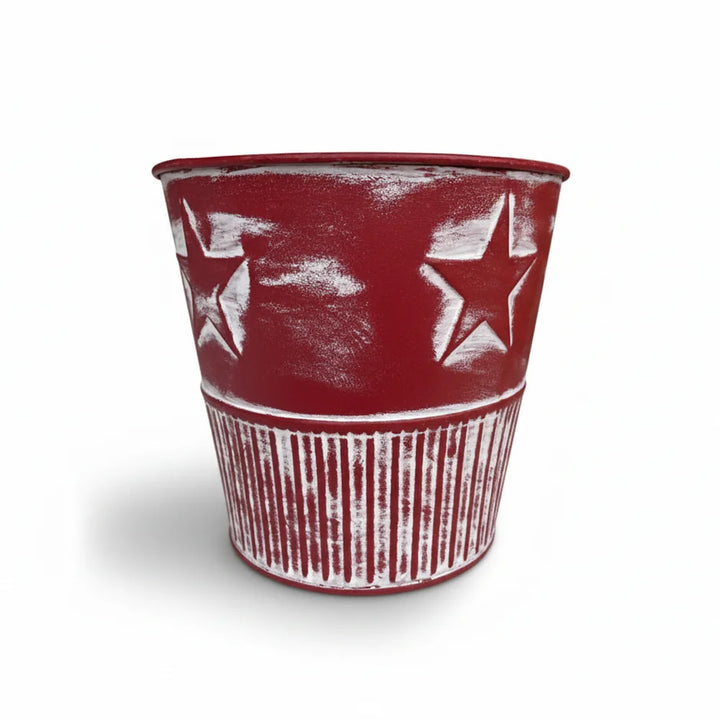 Der Alsaba Home Metall Übertopf Weihnachten Rot ist ein roter Übertopf aus Metall mit weißen Sternen und vertikalen weißen Streifen auf weißem Hintergrund.