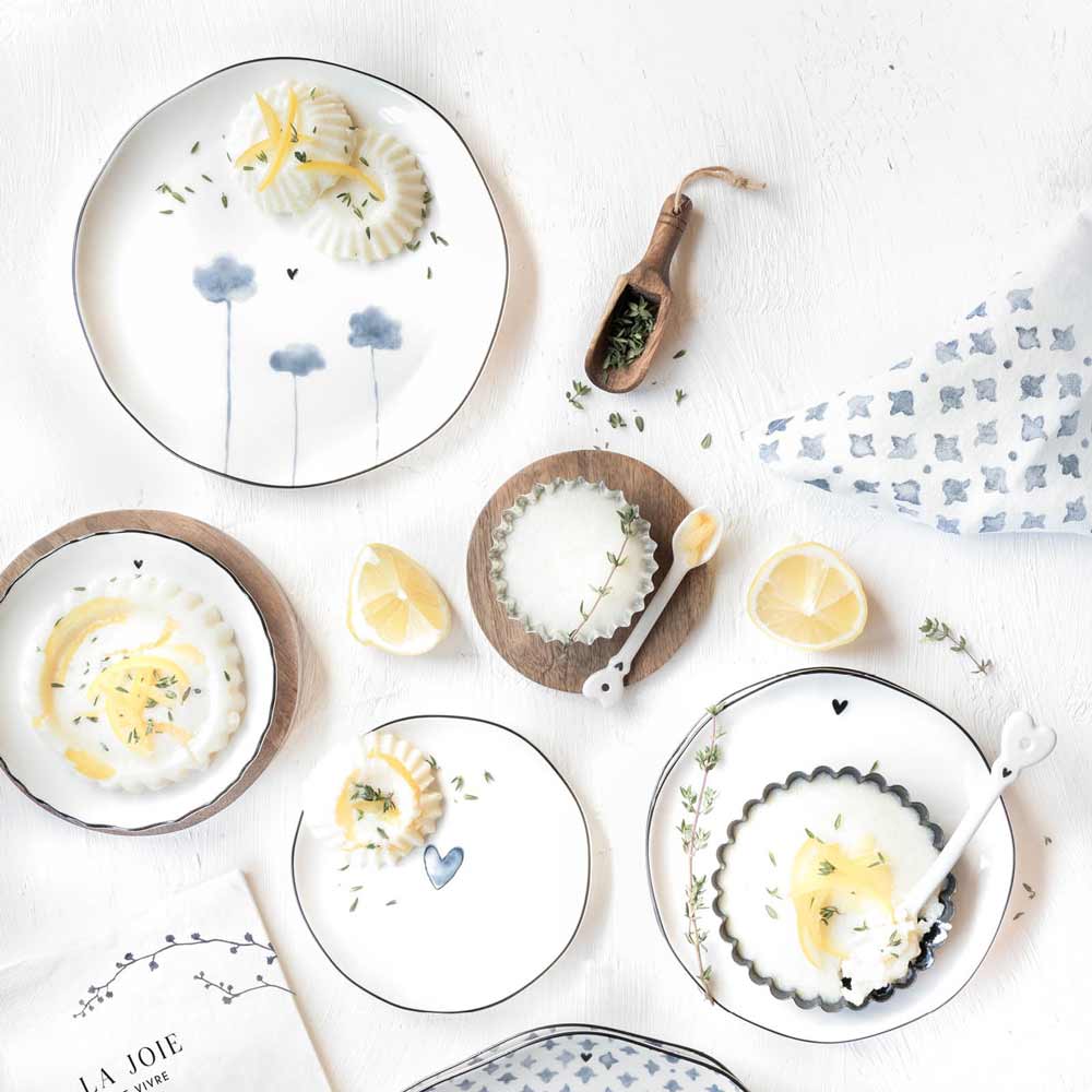 Draufsicht auf einen gedeckten Tisch mit Zitronenscheiben und Bastion Collections – Beilagenteller Iris Blue Heart mit Blumenmotiven.