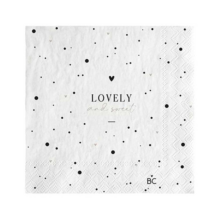 Eine weiße Serviette mit schwarzen Punkten und dem Wort „Lovely“. Diese Bastion Collections - Papierservietten Lovely and Sweet 20 Stück sind eine schöne Ergänzung für jede Tischdekoration, perfekt für Veranstaltungen oder den täglichen Gebrauch.