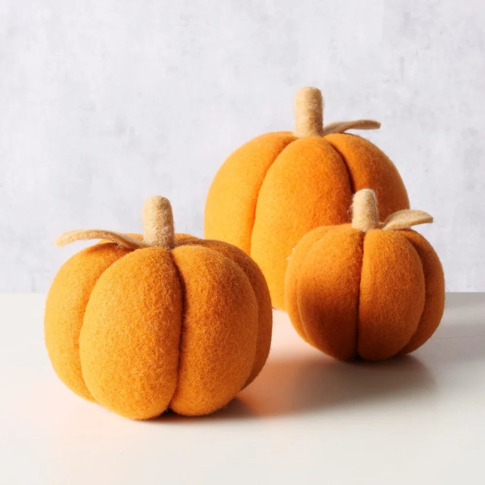 Das Boltze - Dekokürbis Tikva Filz Orange 3er-Set zeigt drei orangefarbene Filzkürbisse mit beigen Stielen, die auf einer weißen Fläche vor einem hellgrauen Hintergrund angeordnet sind.