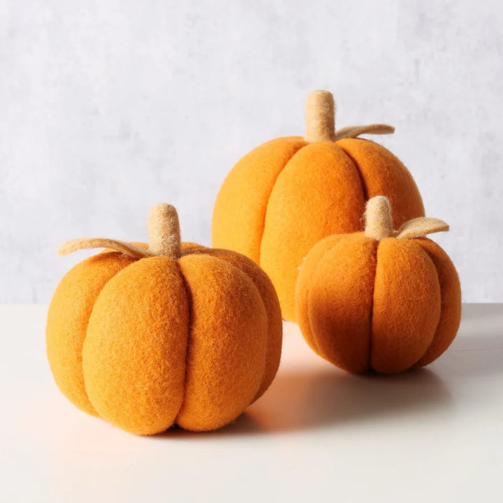 Das Boltze - Dekokürbis Tikva Filz Orange 3er-Set zeigt drei orangefarbene Filzkürbisse mit beigen Stielen, die auf einer weißen Fläche vor einem hellgrauen Hintergrund angeordnet sind.