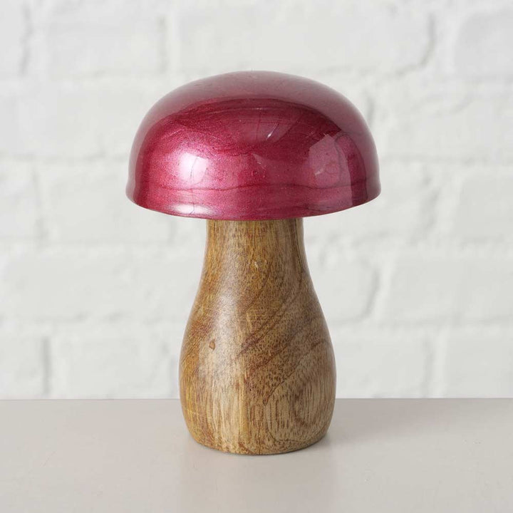 Das Boltze - Pilz Deko Ella bordeaux 3er-Set, bestehend aus einer Holzpilz-Skulptur mit Naturholzstiel und glänzend rotem Hut, steht auf einem hellen Untergrund mit einer weißen Backsteinmauer im Hintergrund.