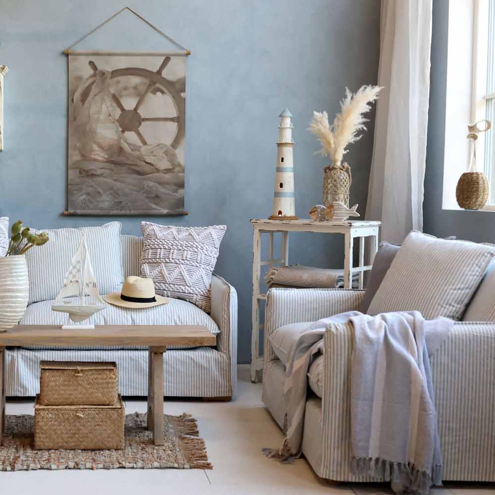 Graublaues Wohnzimmer mit gestreiften Polstern, Holz-Couchtisch und einer hellen Decke über dem Sessel rechts
