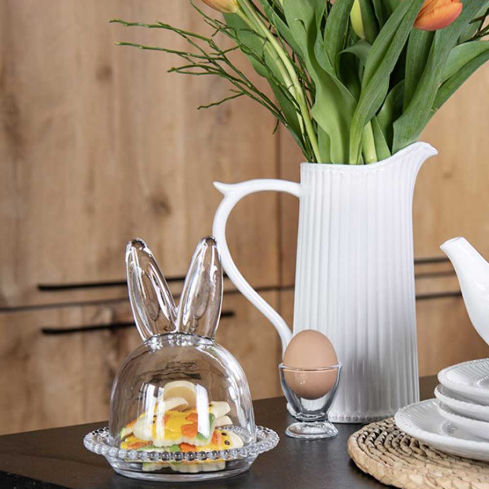 Clayre & Eef - Glasglocke Hase Eierhalter steht auf einem Tisch neben einer Vase mit Tulpen.