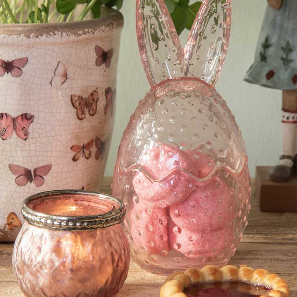 Ein Clayre & Eef - Osterhase Glas Bonbonnière-förmiges Glasgefäß mit einer Kerze darin.