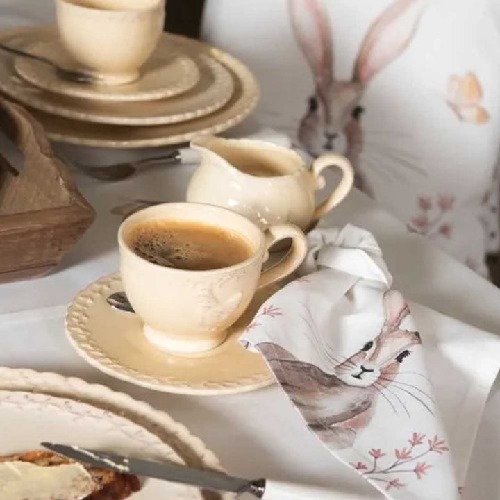 Ein Tisch mit Clayre & Eef - Stoffserviette Hase beige und Tassen Kaffee.