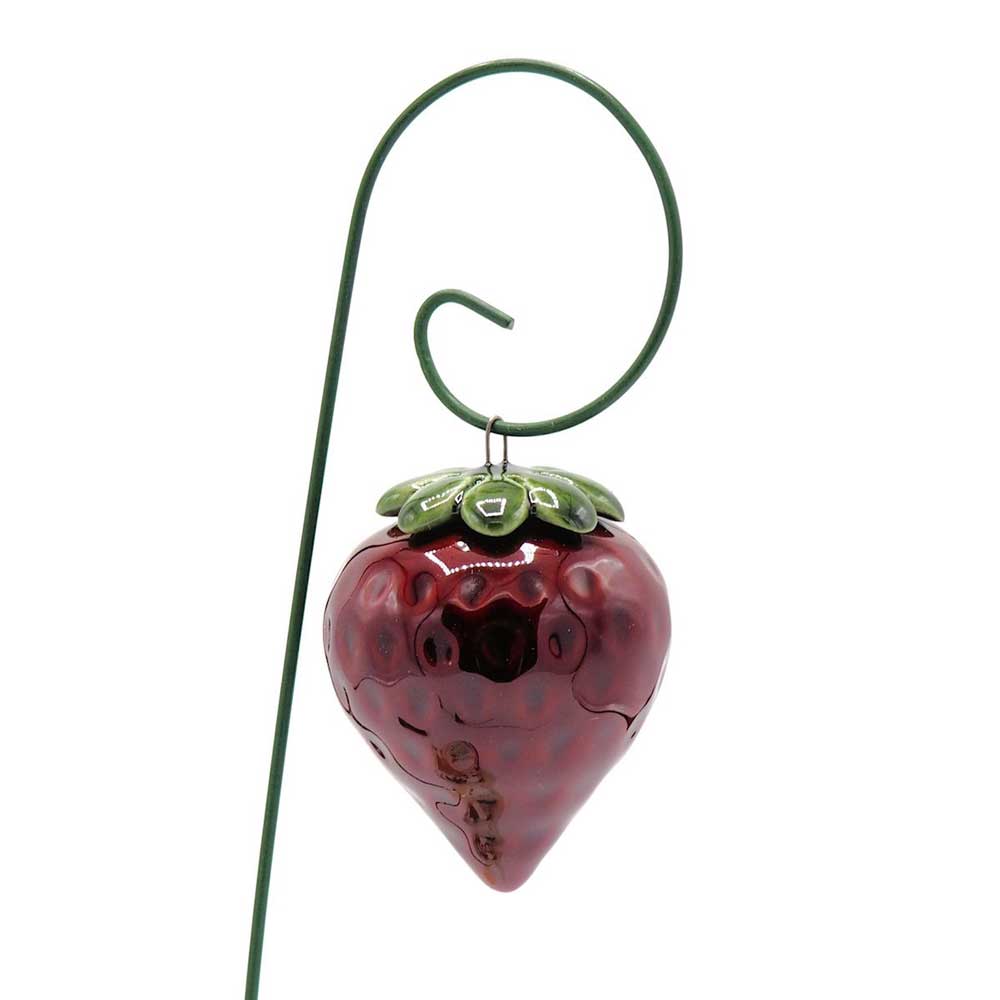 Ein Department-M - Gartenstecker Erdbeere hängt an einer gebogenen, grünen Metallstange.