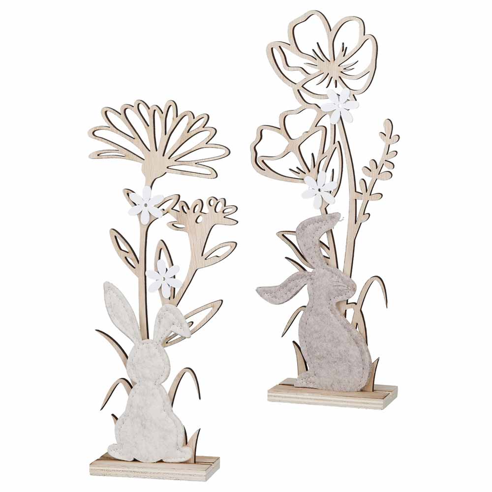 Das Gilde - Hase & Blume Deko Holz Standrelief besteht aus zwei Dekoteilen aus Holz: einmal mit einem Kaninchen und einmal mit einem Hasen, beide geschmückt mit Blumen auf Ständern.