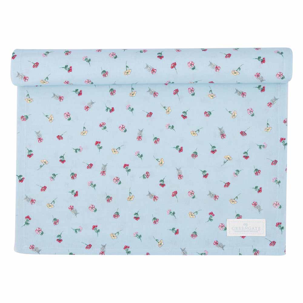 Ein aufgerollter GreenGate - Lianca Tischläufer aus hellblauem Stoff zeigt kleine Blumenmuster in Rot, Rosa und Gelb und ist mit einem rechteckigen Etikett in der unteren rechten Ecke versehen.