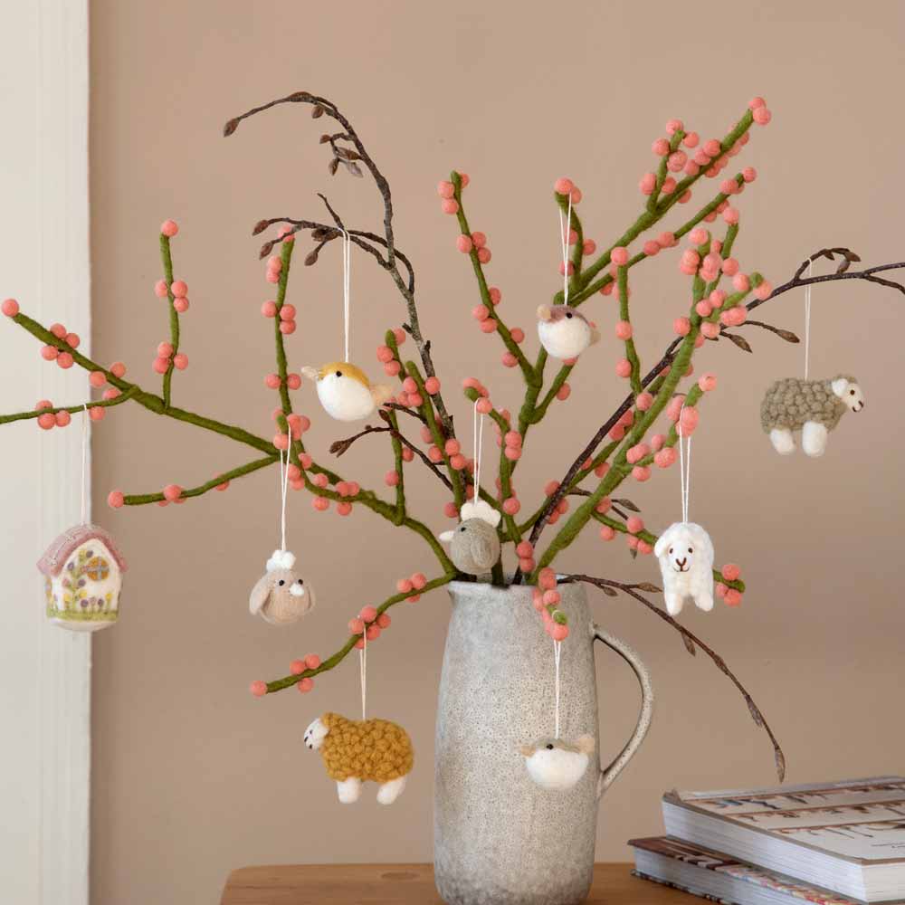 Dekorativer Osterbaum mit hängenden Gry & Sif - Anhänger Hahn Filz 3er-Set Ornamenten in einer Keramikvase.