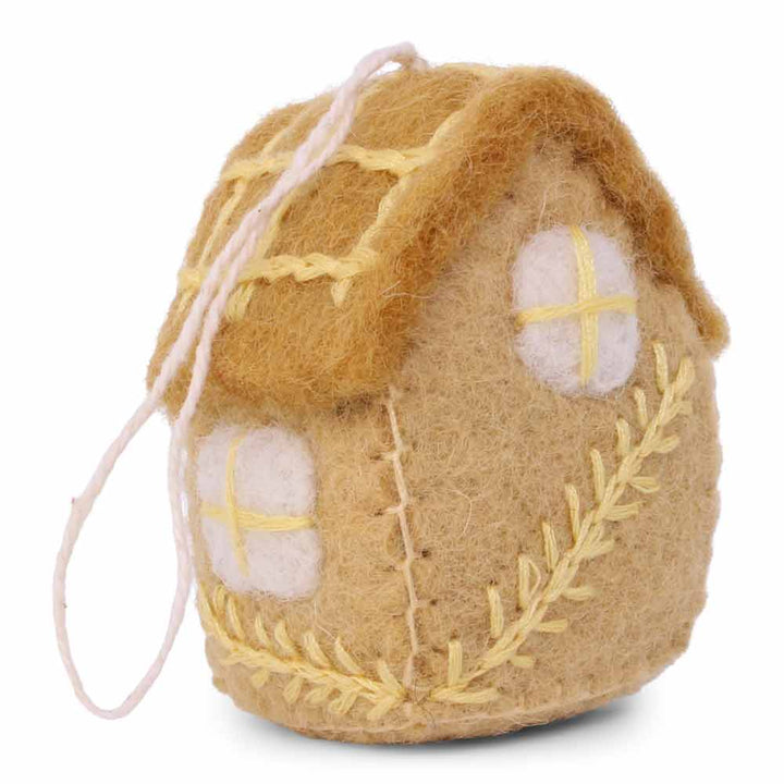 Ein Osterei-Ornament von Gry & Sif, das wie ein gemütliches Häuschen aussieht, komplett mit einer Schnur zum Aufhängen, isoliert auf weißem Hintergrund.