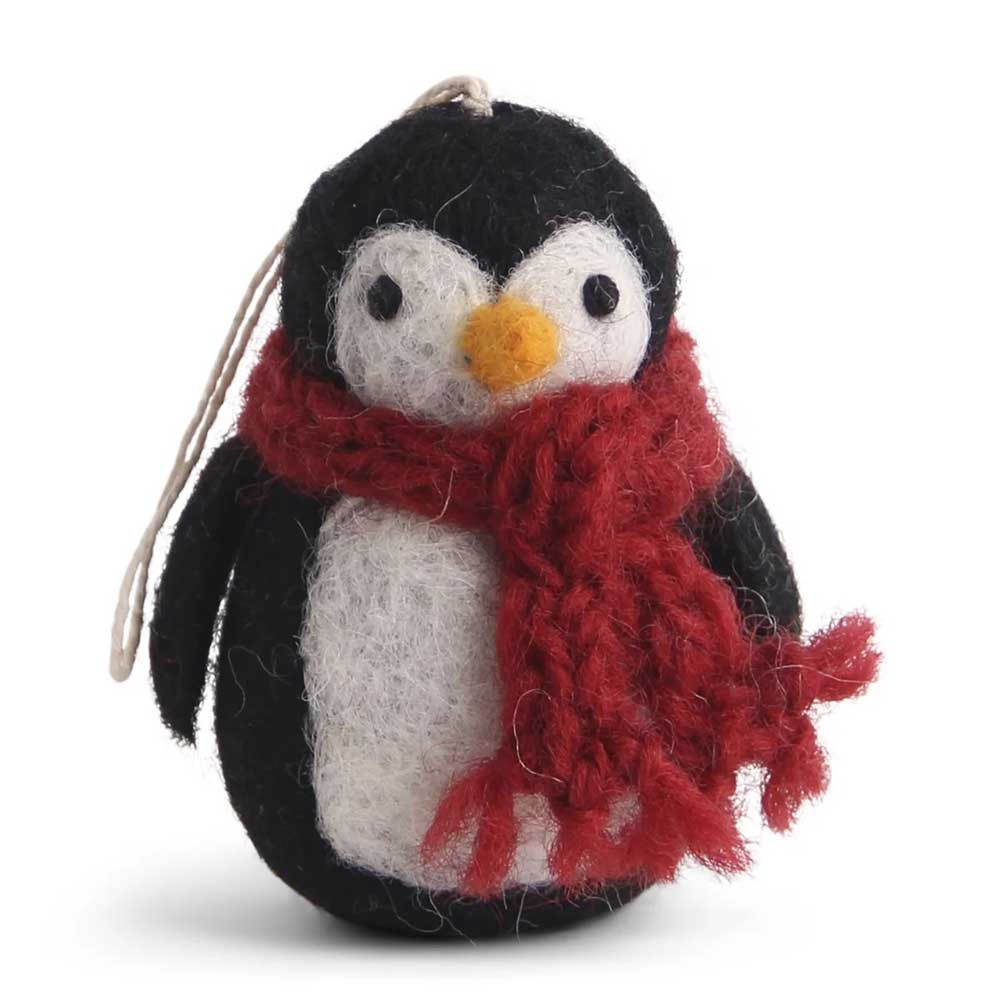 Ein Pinguin-Ornament aus Filz von Gry & Sif mit einem roten Schal und einer daran befestigten Schnur zum Aufhängen.