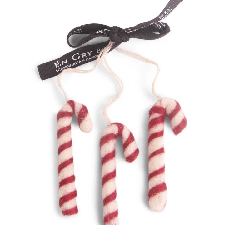 Set aus drei Zuckerstangen-Ornamenten aus Filz von Gry &amp; Sif mit roten und weißen Streifen, alle an einem schwarzen Band befestigt.