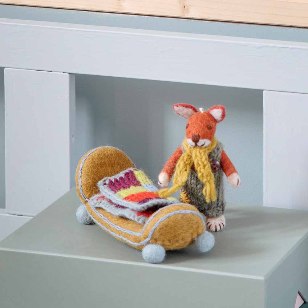 Eine Filzmausfigur mit Schal und Kleid steht neben dem „Bett mit Decke Filz“ von Gry & Sif, einem kleinen Filzbett mit bunten Decken.