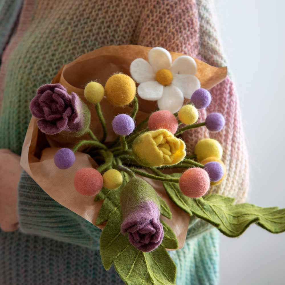 Person hält einen Strauß Gry & Sif - Blume Filz Ø3 Blumen und bunte Filzkugeln.