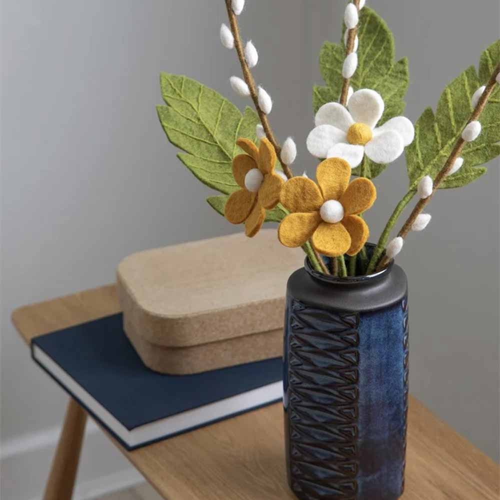 Gry & Sif – Simple Flower Filzblumen in einer blauen Vase auf einem Holztisch.
