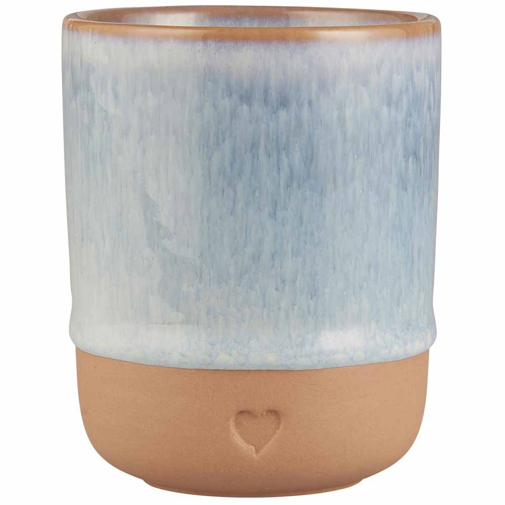 Der Ib Laursen Becher Herz Ton Natur ist eine zylindrische Tasse aus Keramik mit einer blau glasierten oberen Hälfte und einer unglasierten braunen Unterseite mit einem kleinen Herzaufdruck.