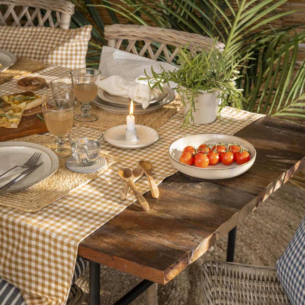 Ein Ib Laursen - Salat-/Pastateller „Sand Dunes“ ist Teil eines Esstisches auf einem Holztisch mit karierter Tischdecke, mit Gläsern, einer brennenden Kerze, Kirschtomaten in einer Schale und einer Topfpflanze.