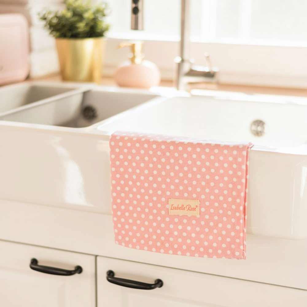 Isabelle Rose – Geschirrtuch mit Punkten mit dem Namen bestickt, hängt über dem Rand einer weißen Küchenspüle, mit Schränken und einer Topfpflanze im Hintergrund.
