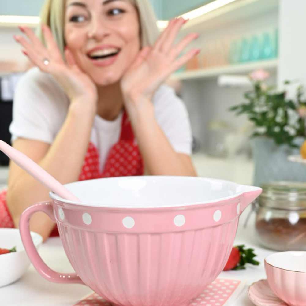 Frau in einer Küche sieht überrascht aus, mit einer großen Isabelle Rose - Rührschüssel Keramik mit Punkten vor ihr.