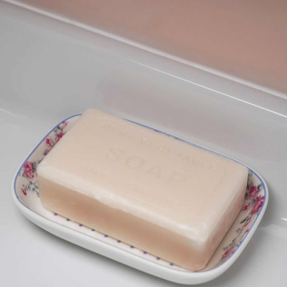 Ein beiges Stück Seife ruht auf einem Isabelle Rose – Seifenhalter Keramik mit floralem Muster.