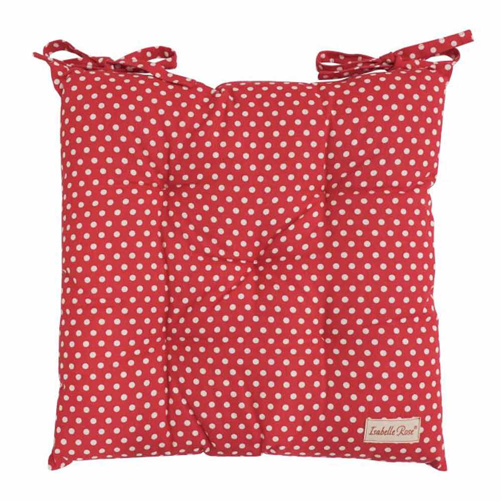 Ein rotes Kissen mit weißen Punkten, kleinen Bindebändern an den Ecken und einem Etikett mit der Aufschrift „Isabelle Rose – Sitzkissen mit Punkten“.
