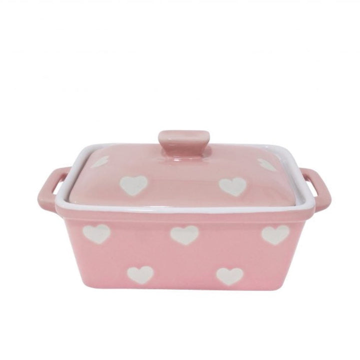 Die Isabelle Rose - Butterdose mit Herzen ist eine rosafarbene rechteckige Butterdose aus Keramik mit weißem Herzmuster, einem Deckel und zwei Griffen.