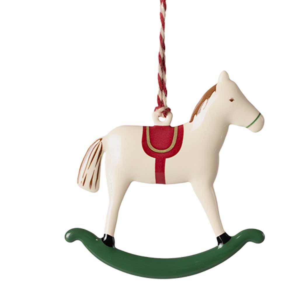 Der Maileg-Anhänger Metall Schaukelpferd ist ein bezauberndes Ornament im Design eines hölzernen Schaukelpferds mit weißem Körper, rotem Sattel, grünem Schaukelfuß und ist mit einer rot-weißen Schnur geschmückt.