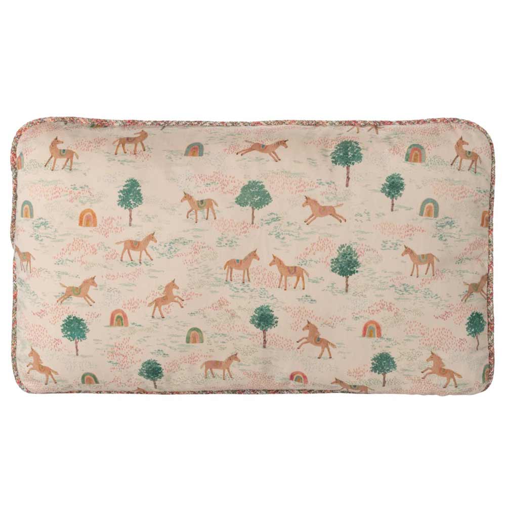 Das Maileg - Kissen Einhorn ist ein rechteckiges Kissen mit einem beigen Hintergrund und einem bezaubernden Muster aus Einhörnern, Bäumen, Regenbögen und Pflanzen in sanften Pastellfarben.