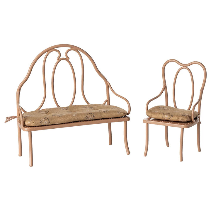Zwei kleine Maileg-Puppenhausstühle im Vintage-Stil in Dunkelrosa mit dekorativen Rückenlehnen und gepolsterten Sitzen - einschließlich einer Bank und eines einzelnen Stuhls.