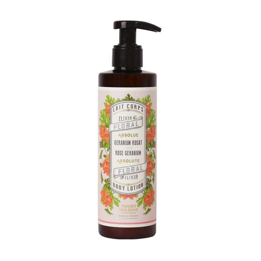 Eine braune Flasche Körperlotion mit einem schwarzen Pumpspender und einem Blumenetikett mit orangefarbenen Blumen und grünen Blättern. Auf dem Etikett steht: „Panier des Sens – Bodylotion Rosengeranie 250 ml“.