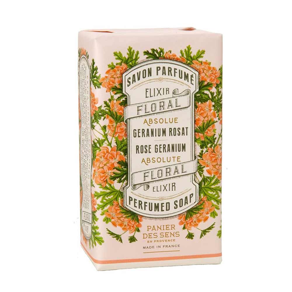 Eine Schachtel parfümierter Seife mit Blumenmuster. Auf dem Etikett steht „Panier des Sens – Feste Seife mit Duft Rosengeranie 150 g“ und es wird darauf hingewiesen, dass die Seife von Panier Des Sens in Frankreich hergestellt wird.