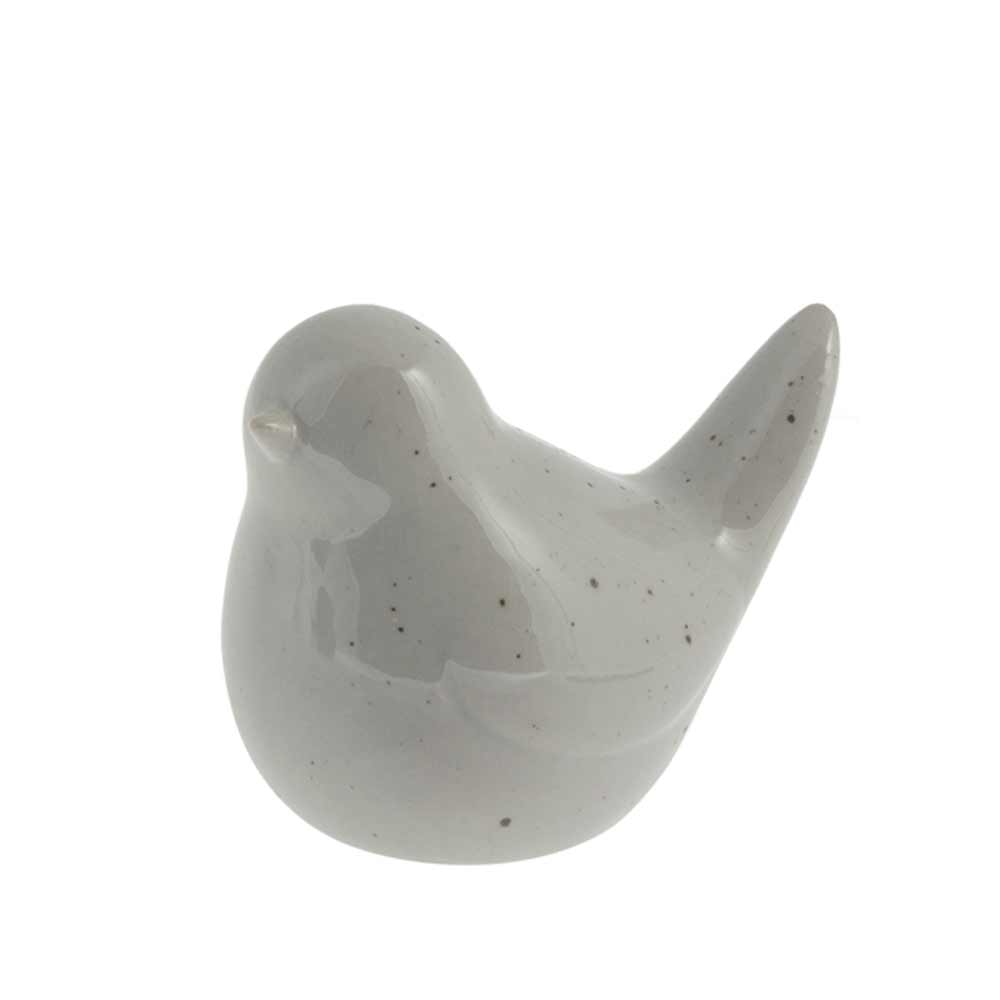 Eine kleine graue Vogelfigur aus Keramik mit glänzender Oberfläche, isoliert auf weißem Hintergrund von Storefactory – Herman Vogel.