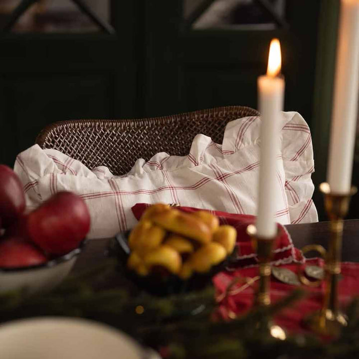 Ein elegantes Esszimmer mit brennenden Kerzen, einem Korb Brot und frischem Obst auf einem Tisch.
Produktname: Strömshaga - Kissenbezug Alma 45 x 45 cm