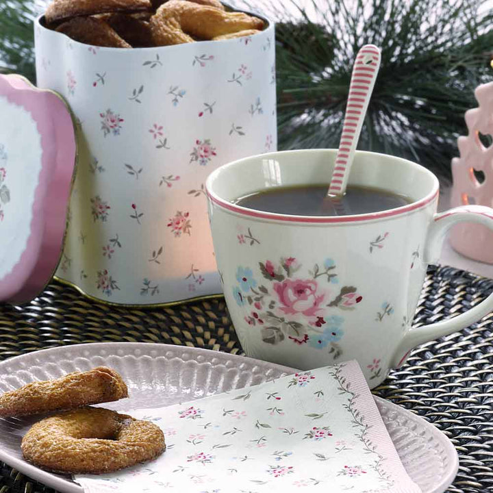 Eine GreenGate - Teelichthalter Tanne steht auf einem Teller neben Keksen und einer Serviette, im Hintergrund ist eine Dose mit Blumenmuster und weiteren Keksen zu sehen. Hinter der Dose sind Tannenzweige zu sehen.