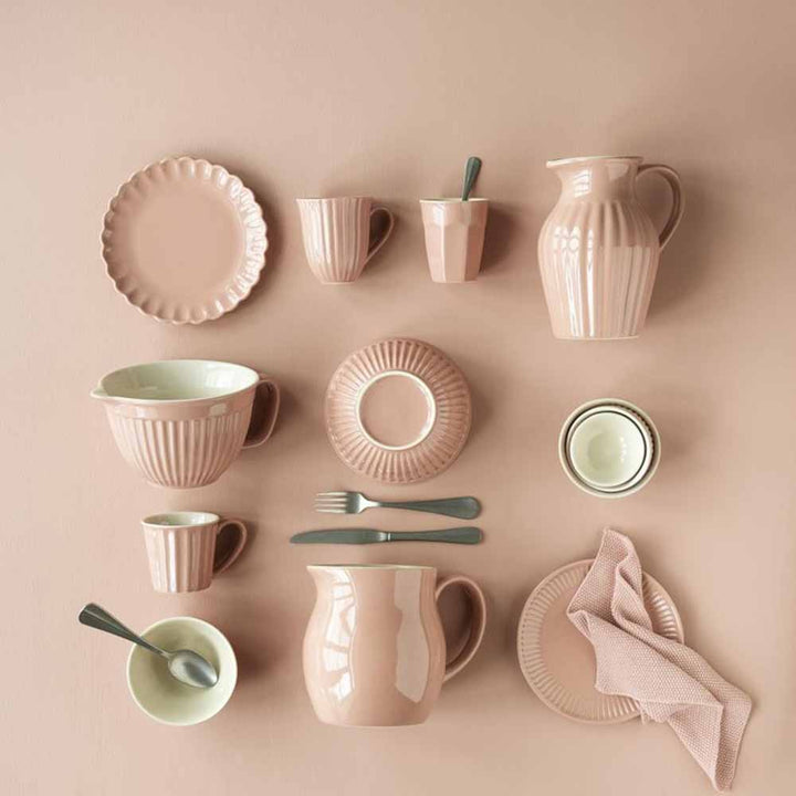 Eine Kollektion von Ib Laursen - Cafe Latte Becher Mynte-Geschirr aus pastellrosa Keramik, hübsch arrangiert auf einem sanften beigen Hintergrund.