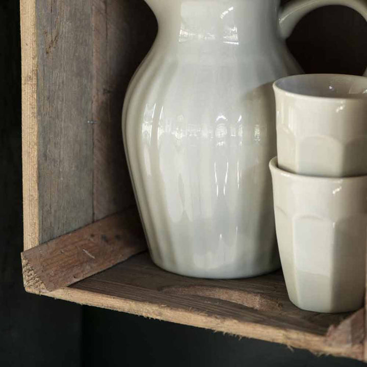 Satz mit Produktname: Ib Laursen - Cafe Latte Becher Mynte Krug und Tassen auf einem rustikalen Holzregal vor einem dunklen Hintergrund angeordnet.