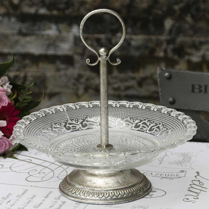 Chic Antique Etagere mit gepresster Glasschale und Ring-Griff in Silberoptik, daneben rosa Rosen vor einer Backsteinwand